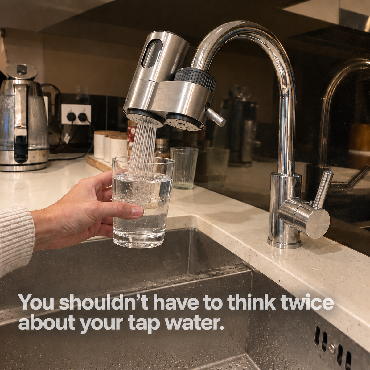 Filling a glass with filtered water from Aurio on a kitchen mixer tap